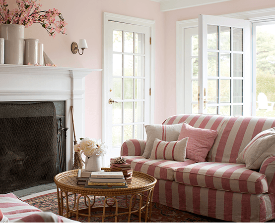 Interior image of a living room with open French doors and a pinstriped sofa.