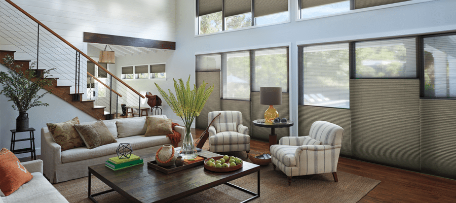 Home Living Interior image of a large, modern living room with pinstriped chairs, a couch, and half-drawn shades.